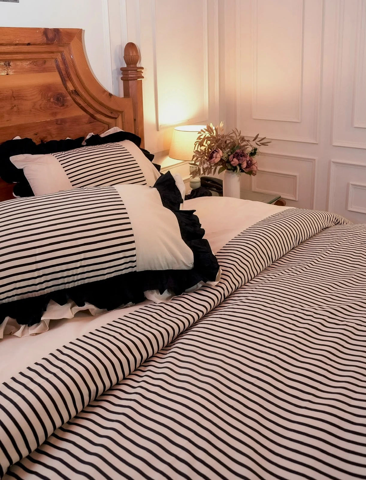 The Colette Cover Set by Uahan — black and ivory striped duvet cover with ruffled pillow covers, lamplit bedroom