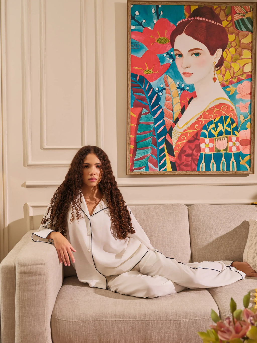 The Opaline Set by Uahan, lounging on a linen sofa beneath a painted portrait